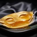 Seidenmaske mit goldener Honig-Textur und sanftem Schimmer auf einem dunklen Tablett